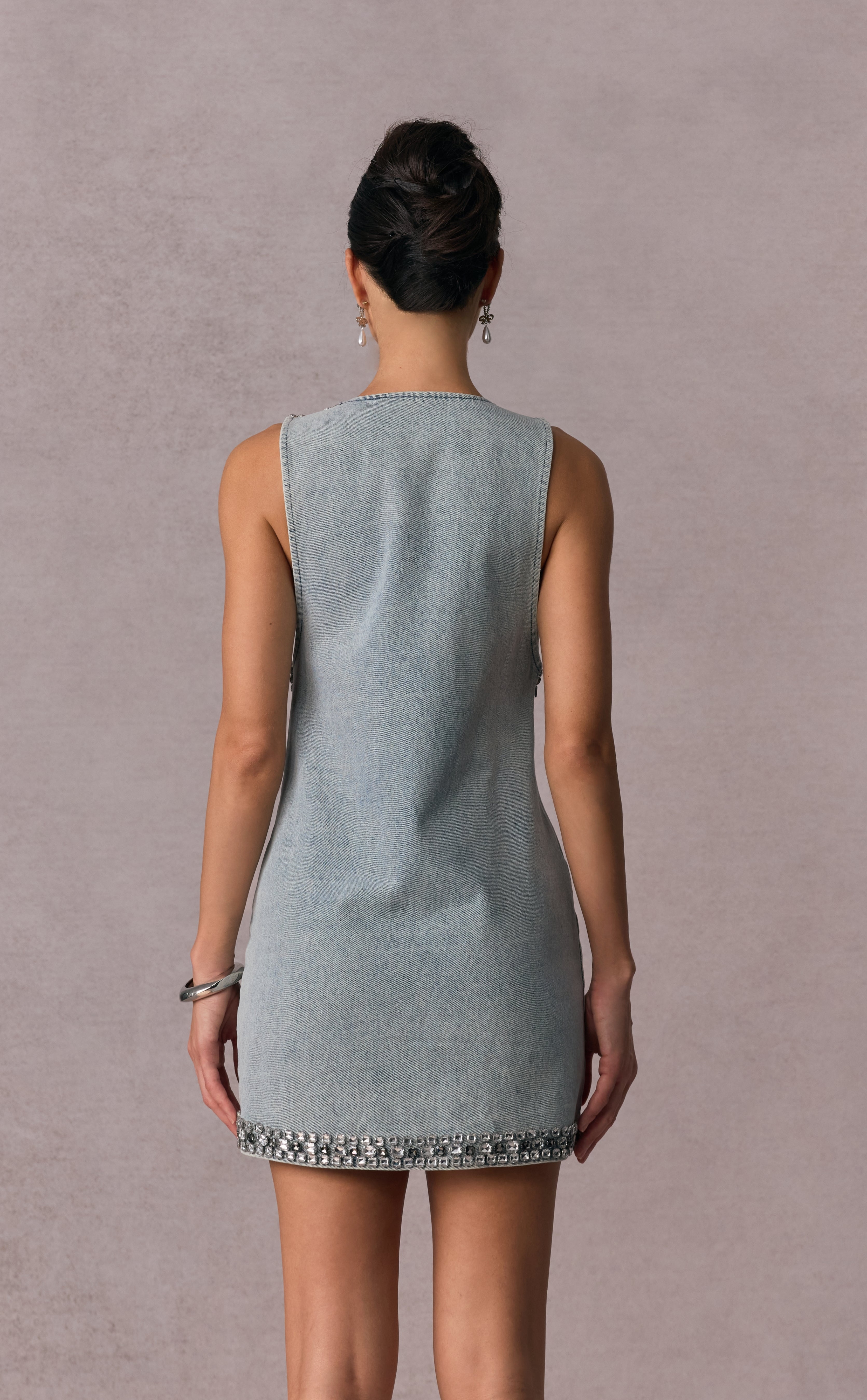 Woman wearing a light blue dress with a plain background