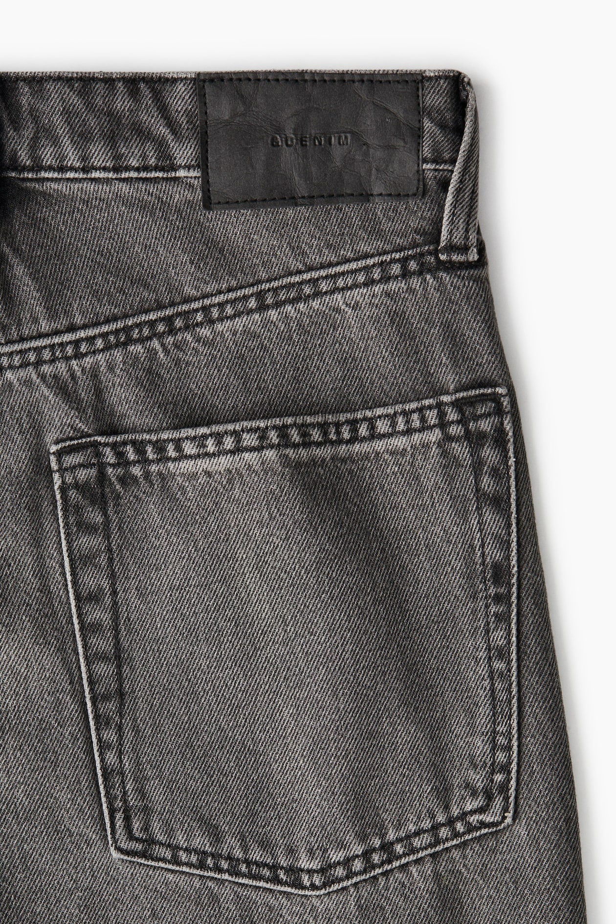 Close-up of a gray denim pocket on a white background