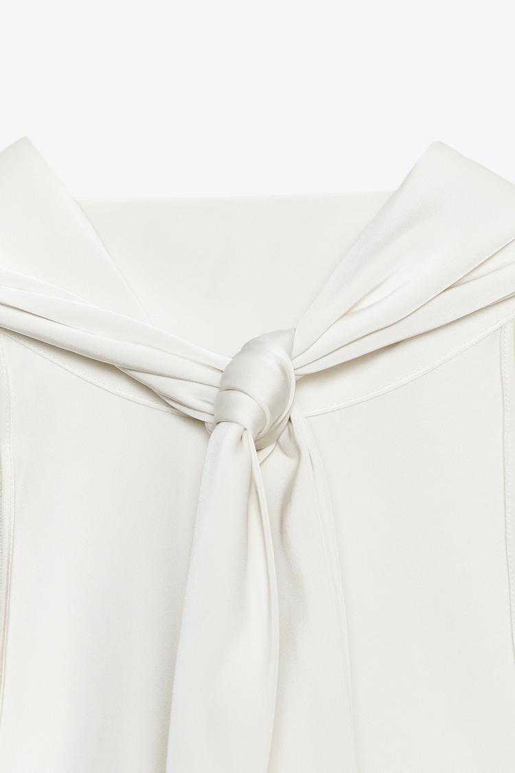 Close-up of a white fabric with a knot on a light beige background