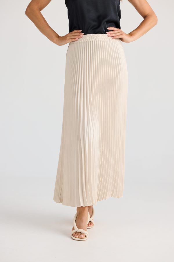 Person wearing a beige pleated skirt on a white background