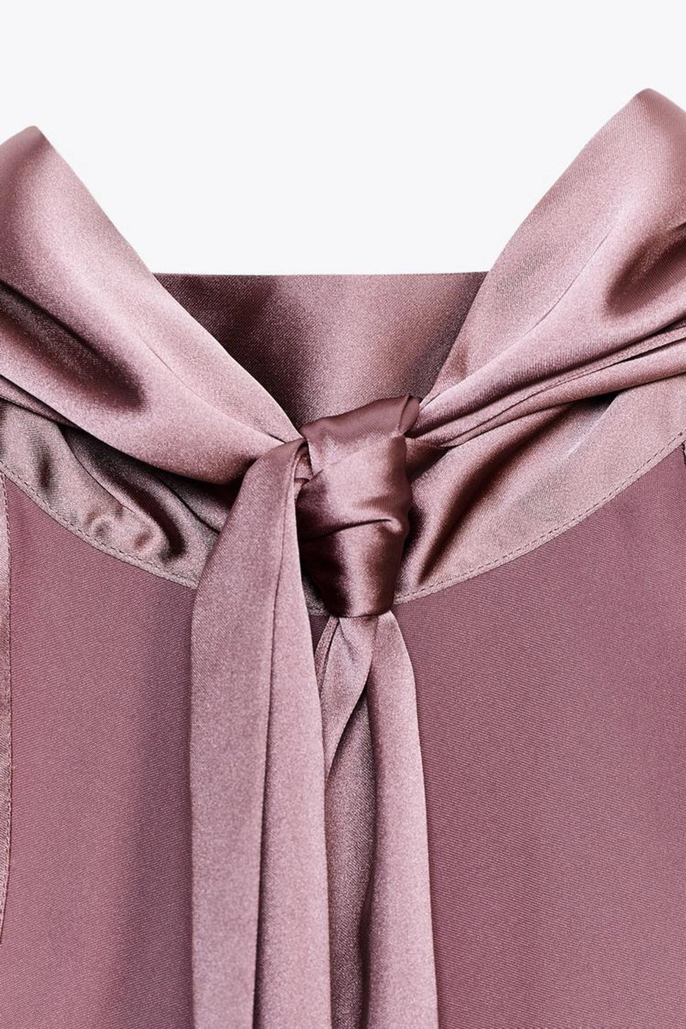 Close-up of a mauve satin bow on a matching fabric background