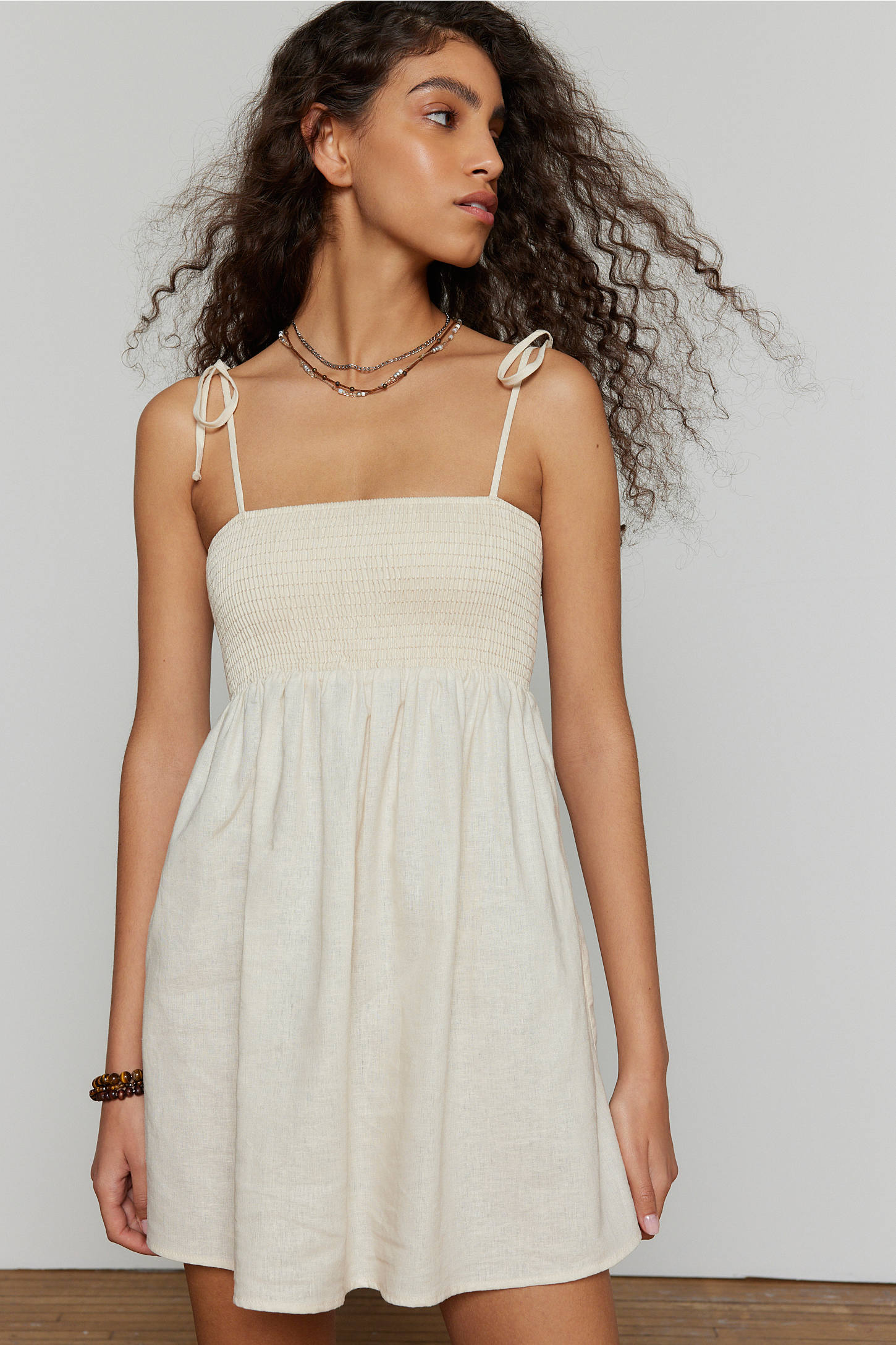 Woman wearing a white dress against a plain background